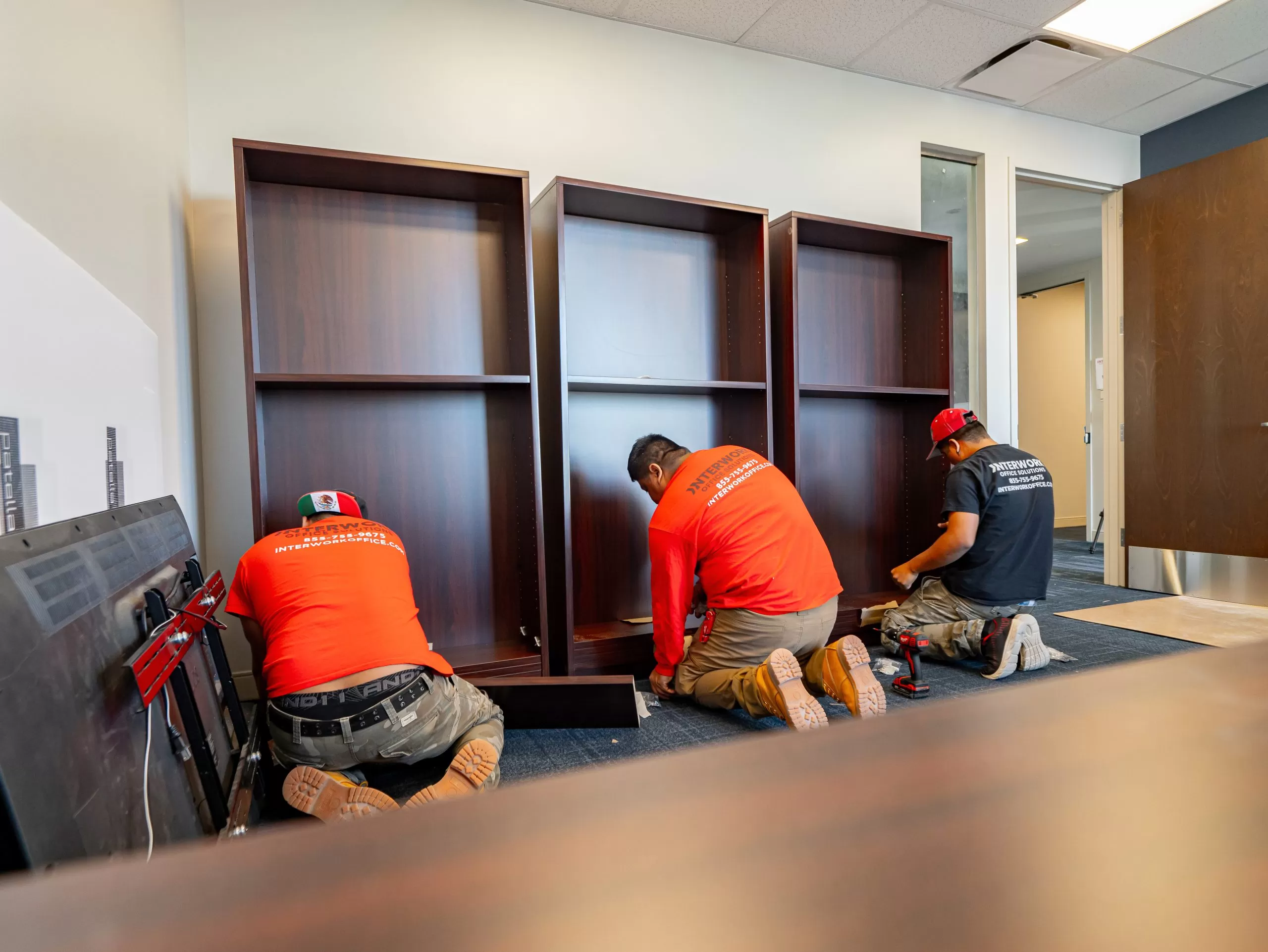 Office movers assembling bookcases.
