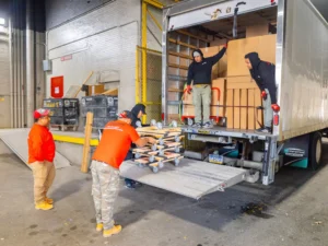 Workers unloading boxes from truck.