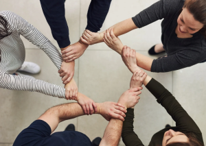Teamwork, unity, hands clasped, circle.